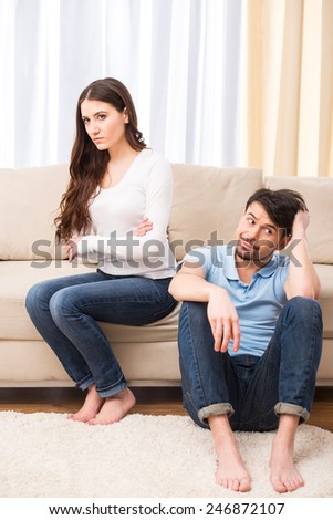Upset young couple are having marital problems or a disagreement are ignoring one another.
