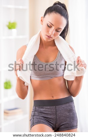 Young tired woman after fitness exercise with towel.