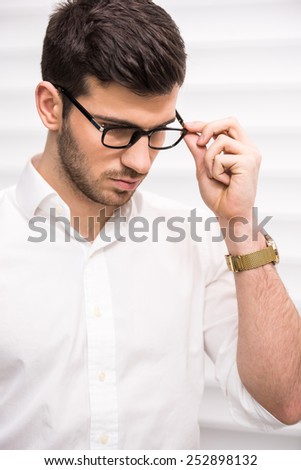 Young handsome  self-confident man with glasses. Close-up.