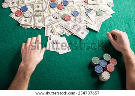 Top view of a poker table during a game. Chips, money and cards on the table.