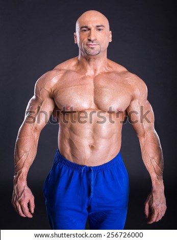Bodybuilder is posing, showing his muscles. Force, relief, muscle, courage, virility, bodybuilder, bodybuilding. The concept of a healthy lifestyle.