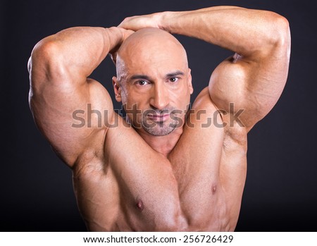 Bodybuilder is posing, showing his muscles. Force, relief, muscle, courage, virility, bodybuilder, bodybuilding. The concept of a healthy lifestyle.