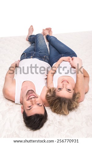 Top view of young beautiful couple are lying on the quality mattress.