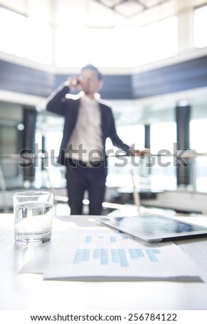 Focus on the things on the table. Blurred man on background.