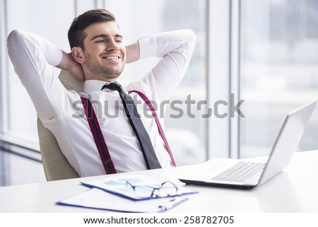 A time for relax. Young, happy businessman is relaxing in his office.
