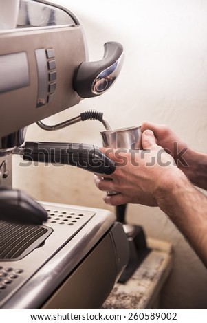 Hand\'s of barista prepares espresso in his coffee shop.