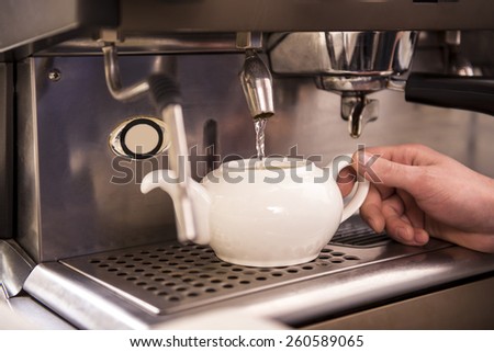 Close-up of professional coffee machine with kettle.