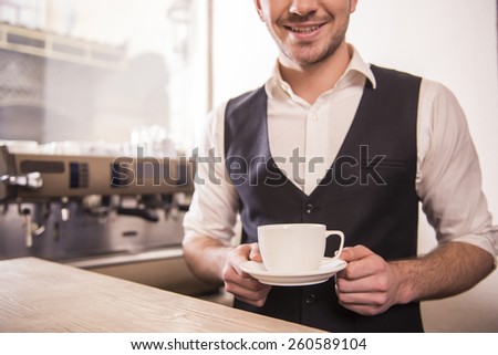 Barista prepares coffe in his coffee shop.