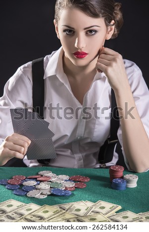 Beautiful and dangerous. Young female gangster play poker. isolated on dark background.