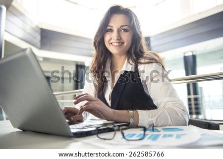 Young business woman working for a laptop in a modern office.