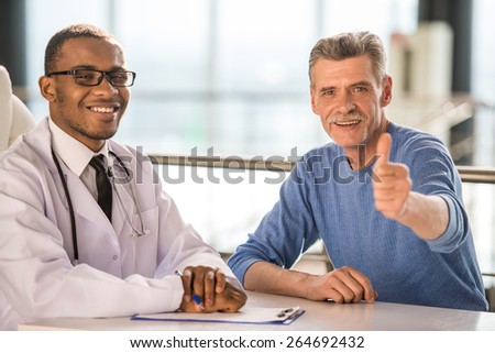 Medical concept. The doctor and patient smiling and thumbs up. Looking at camera.