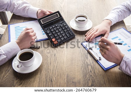 Close-up. Side view. Accounting. Financial analysis. Businessman analyzing graphs with cup of coffee in restaurant.