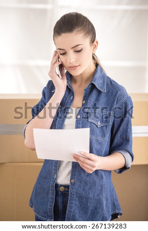 The young happy woman calling transport company to move in new house.