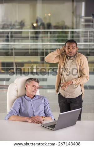 Young worker watching that his colleague sleep in office.