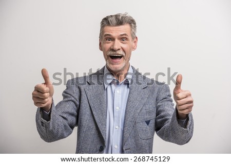 Portrait of a senior man with thumbs up.