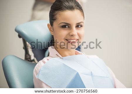 Portrait of mid adult brunette female patient smiling in dentistry.