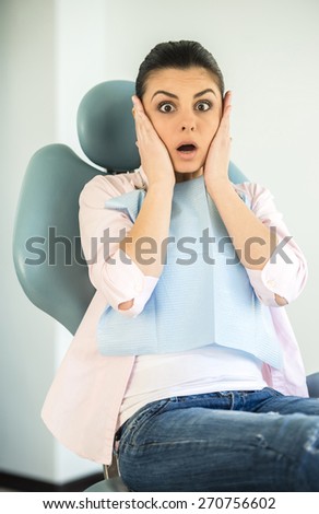 Portrait of mid adult female patient scared in dentist office.