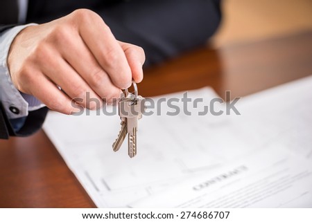 Close-up of hand of man is holding a key from a new apartment.