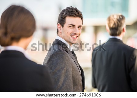 Young smiling handsome confident businessman in suit at a meeting.