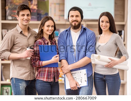Creative group of designers dressed casual looking at camera and smiling.