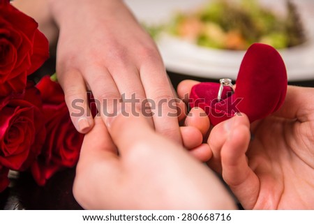 Man making proposal with the ring to his girlfriend at the restaurant.