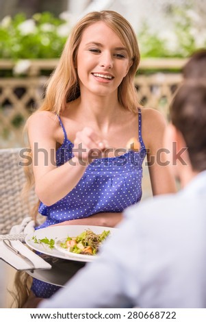 Young happy couple sitting in gorgeous restaurant. Woman feeding man.