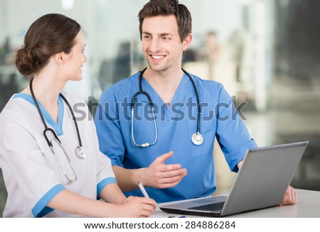 Group of doctors working together on a laptop at doctor\'s office.