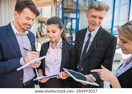 Group of successful business people in suits discussing business strategy.
