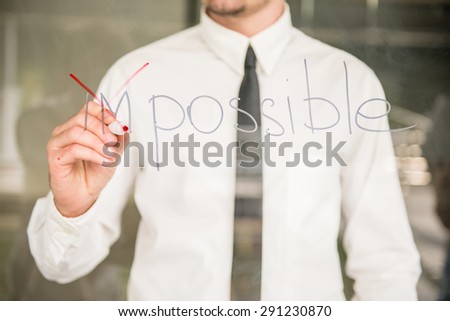Young business coach writing success concept on glass board with marker.