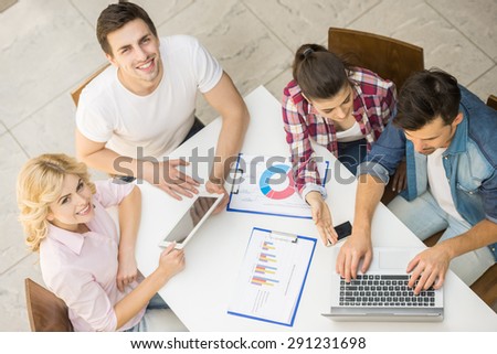 Young successful team dressed casual sitting at office and discussing business plan.