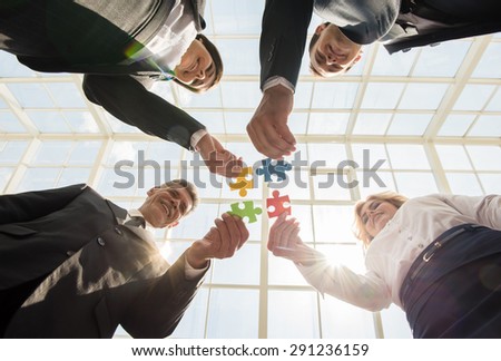 Image of confident business people wanting to put pieces of puzzle together. Team work.