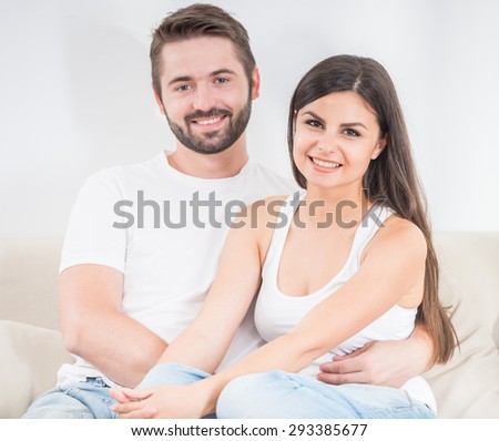 Young attractive couple resting on the sofa at new house after move.