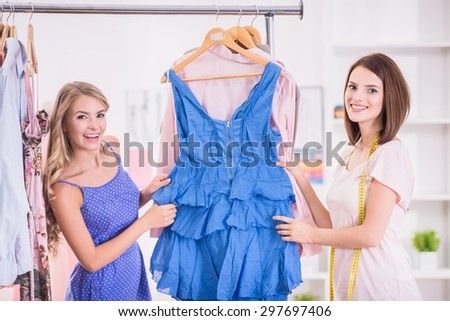 Confident woman choosing clothes on a rack in a showroom.