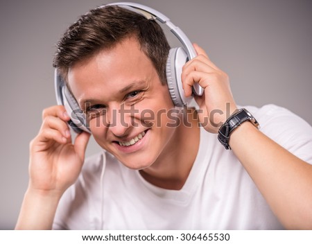 Portrait of young people use headphones on a gray background
