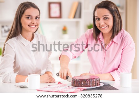A happy family. Mother and teen daughter at home to eat dessert