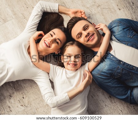 Similar – Image, Stock Photo Lovely portrait of handsome man and beautiful woman with their baby son, looking at camera, while sitting on their home terrace floor.