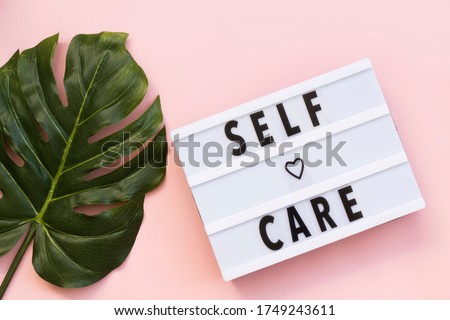 Self-care word on lightbox on pink background flat lay. Take care of yourself
