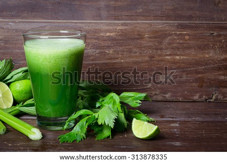 Celery smoothie in the glass on the dark rustic wooden table.