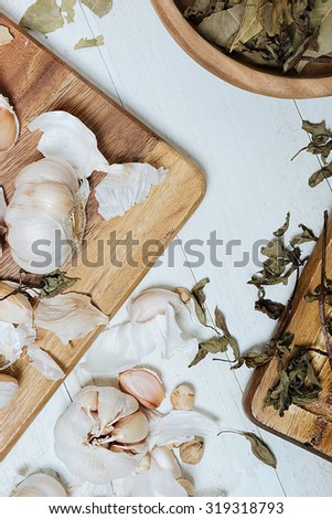 Garlic cloves, laurel leaves and dry basil on the vintage table. Still life