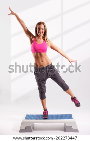 Beautiful fitness model working out on aerobic step