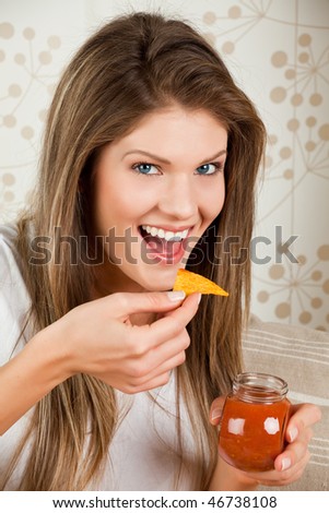 Young beauty woman eating chips and salsa