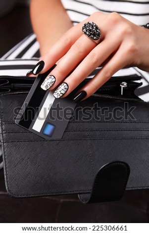 Beautiful nail polished hand holding a credit card