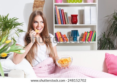 Happy woman eating chips