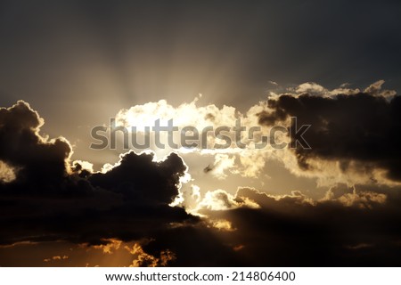 Sunset sky with dark clouds and sun rays