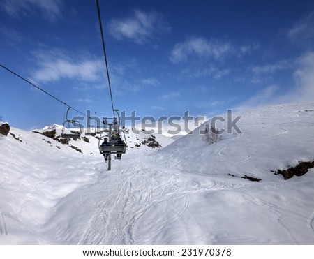 Chair-lift and off-piste slope in sun day. Caucasus Mountains, Georgia, ski resort Gudauri.