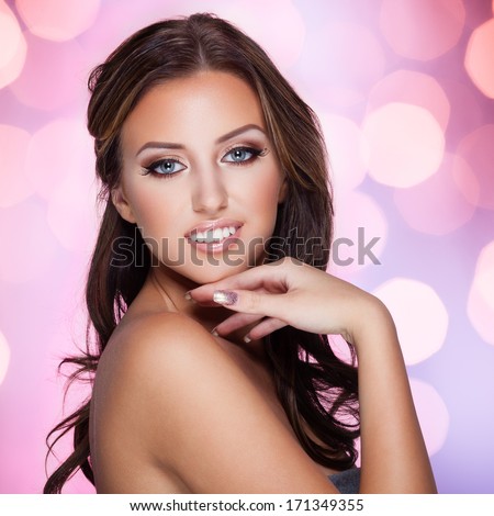 Closeup portrait of a beautiful lady on sparkling pink background