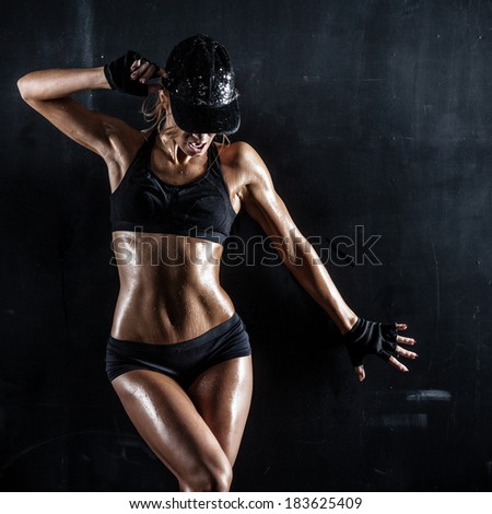 Sexy woman in a cap posing on dark background