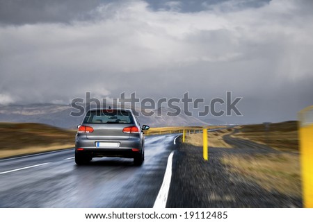 A new car driving fast on a road in a countryside