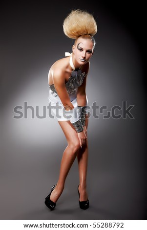Fashion female model in shiny dress on grey background