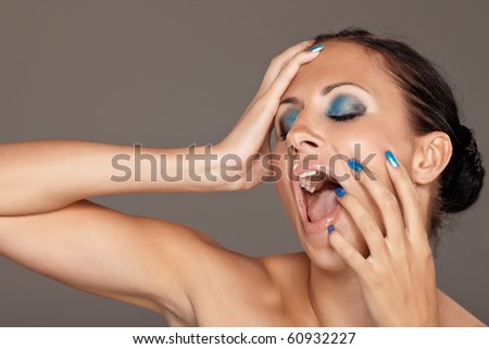Young woman shouting on grey background